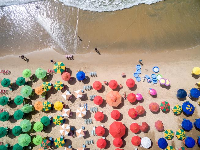 Windswept Beach Umbrella Pierces Woman's Chest