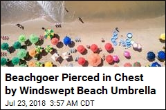 Windswept Beach Umbrella Pierces Woman&#39;s Chest