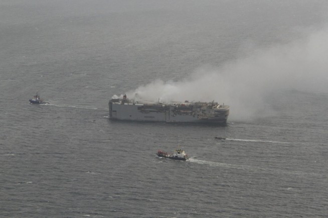 Tugs tow burning cargo ship to new location on North Sea while salvage crews ponder next steps