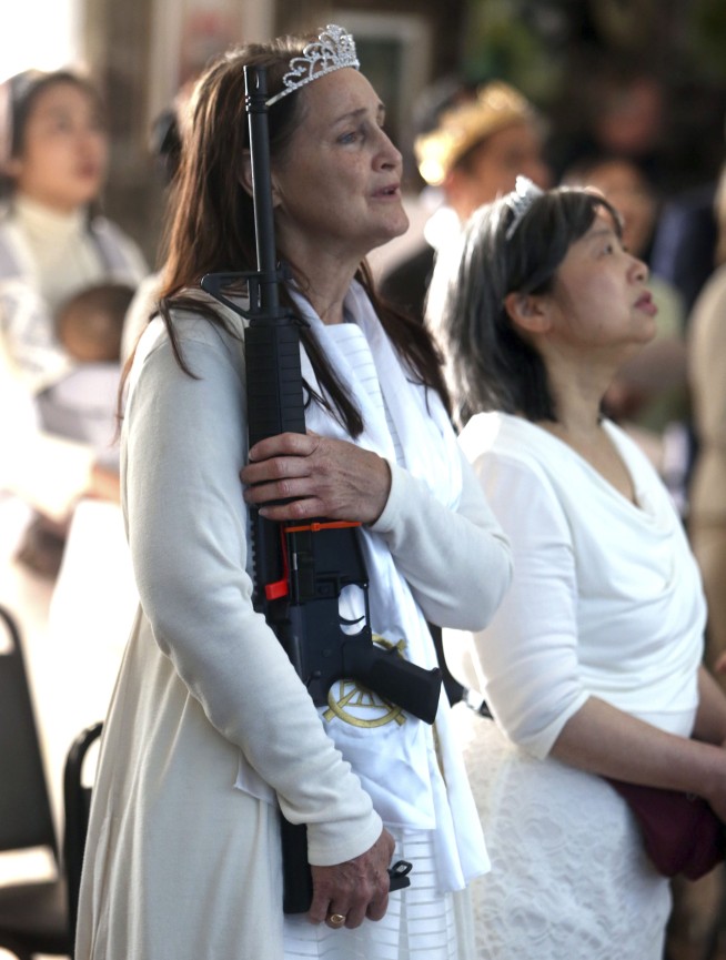 Worshippers clutching AR-15 rifles hold commitment ceremony