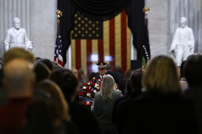 The Latest: Mrs. Obama smiles after George W Bush greeting