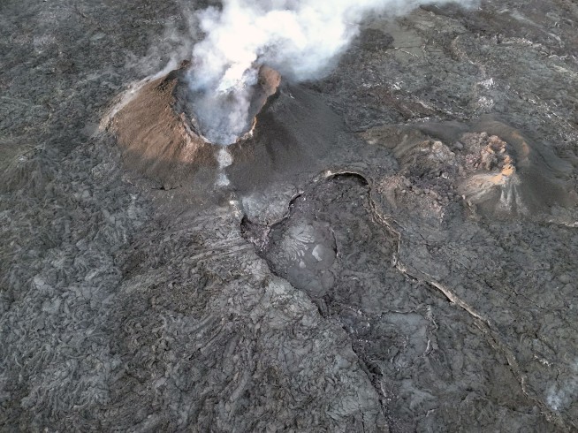 An Iceland volcano spews red streams of lava toward an evacuated town