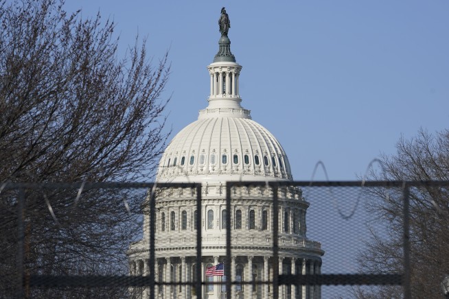The Latest: Guard, police at Capitol fence; Mall deserted