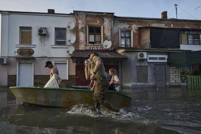 Ukrainians make desperate escape from floods after dam collapse as shelling echoes overhead