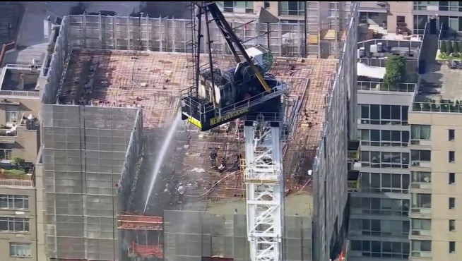 Pedestrians scatter as fire causes New York construction crane's arm to collapse and crash to street