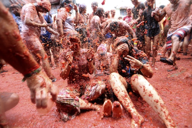 Revelers hurl tomatoes at each other and streets awash in red pulp in Spanish town's Tomatina party