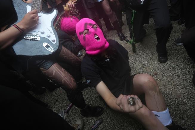 Protesters in pink balaclavas swarm Russia's pavilion at Venice Biennale and release colored smoke