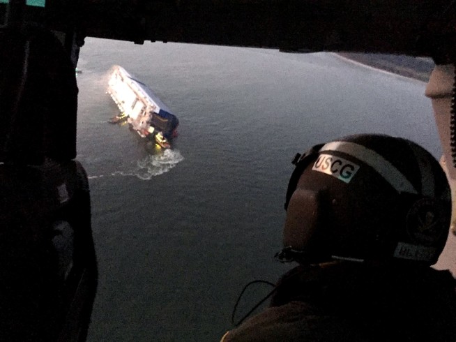 Rescuers pull 3 from capsized cargo ship, 1 still trapped