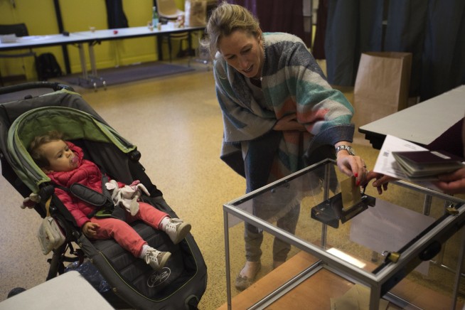 The Latest: Macron, Le Pen advance to France runoff