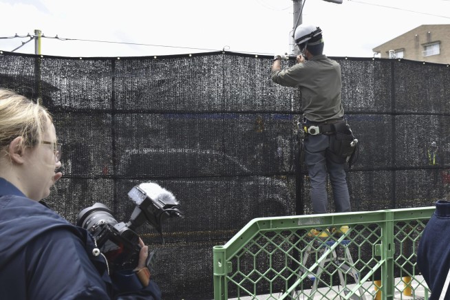 The screen set up to block tourist snapshots of Mount Fuji has several holes in it