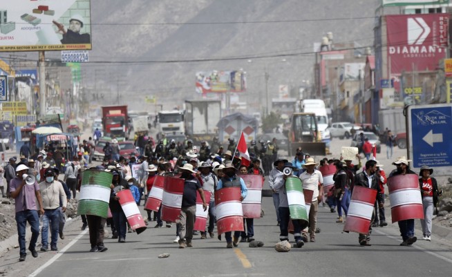 Peru's protest 'deactivators' run toward tear gas to stop it