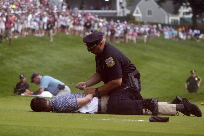 Six climate protesters run onto 18th green and spray powder, delaying finish of PGA Tour event
