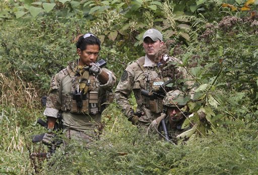 Police on manhunt find pipe bombs in woods