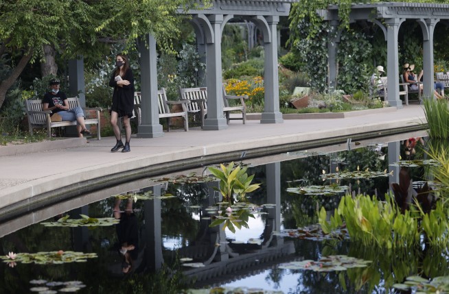 The Latest: US to advise health care workers to reuse PPE