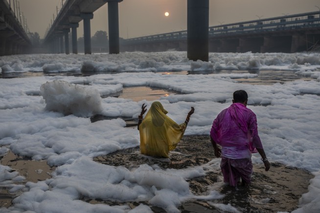 'What fear?': Hindus bathe in frothy, polluted Indian river