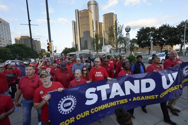Workers strike at all 3 Detroit automakers, a new tactic to squeeze companies for better pay